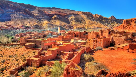 View of Bou Tharar village showing traditional Berber architecture with mountain in background, the Valley of Roses, Morocco